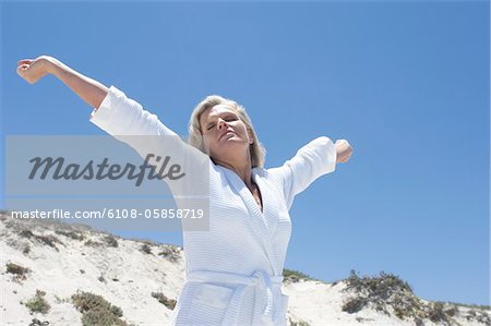 Femme en peignoir, qui s'étend sur la plage