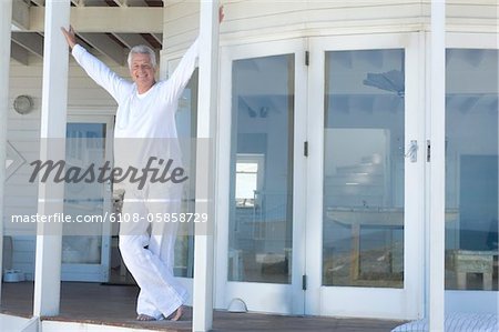 Homme souriant, debout sur une terrasse en bois