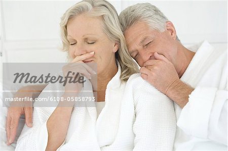 Couple en peignoir avec les yeux fermés
