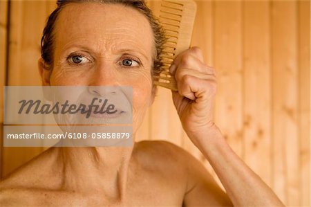 Portrait of senior woman combing her hair