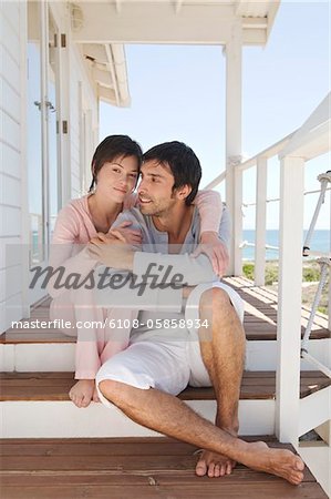 Couple embracing, assis sur la terrasse en bois