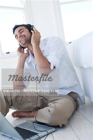 Young man listening to music with laptop