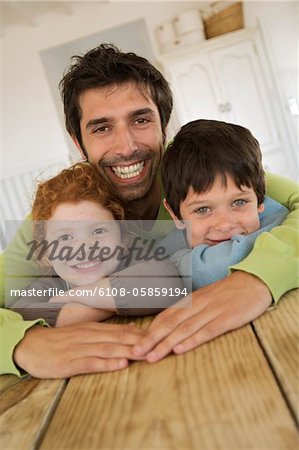 Father and 2 children smiling for the camera