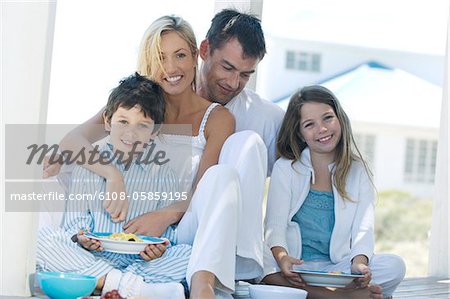 Paar und zwei Kinder, Essen, sitzen auf der Holzterrasse