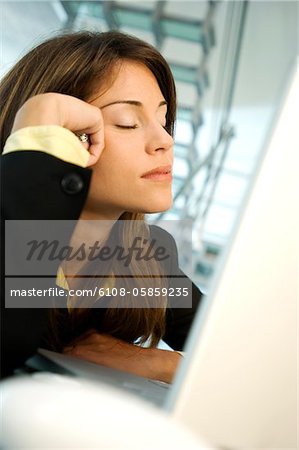 Businesswoman sitting with eyes closed, side view