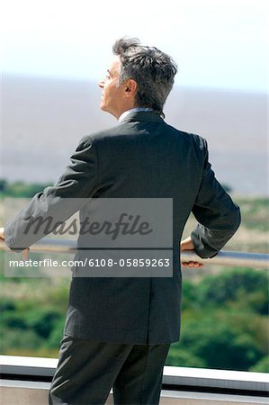Mature businessman standing in balcony