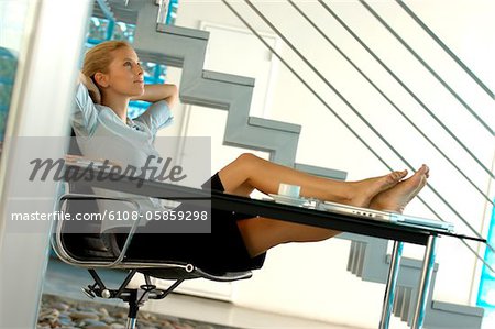 Young businesswoman relaxing on office chair