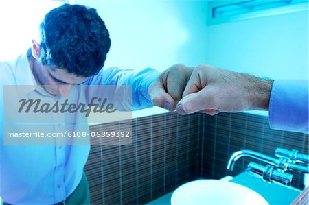 Reflection of mid adult man in mirror at washroom