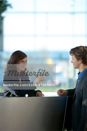 Receptionist giving the key of a hotel room to a businessman