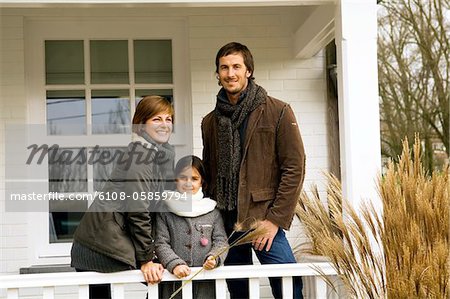 Fille avec ses parents en souriant dans un balcon