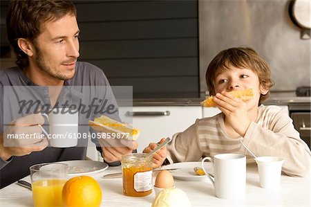 Mid homme adulte prenant son petit déjeuner avec son fils