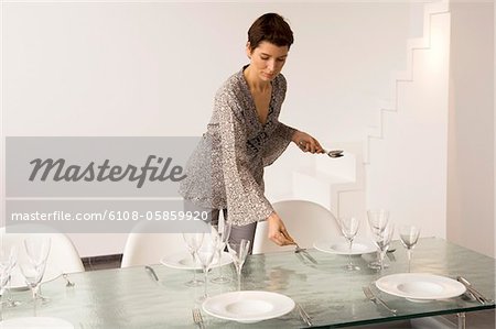 Mid adult woman setting a dining table