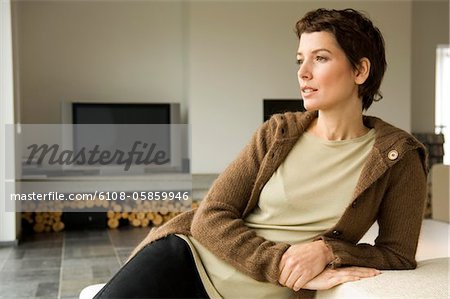 Mid adult woman leaning against a couch