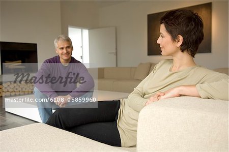 Frau mittleren Alters und ein älterer Mann sitzt in einem Wohnzimmer