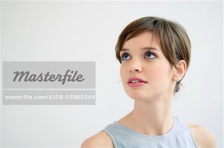 Close-up of a young woman looking up and thinking
