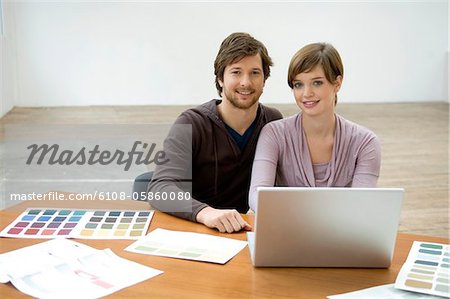 Portrait d'un homme adult moyen et une jeune femme à l'aide d'un ordinateur portable