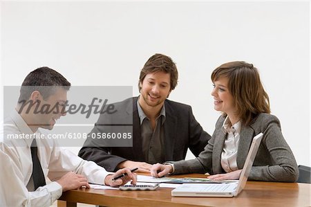 Agent immobilier discute avec un homme adult moyen et une jeune femme