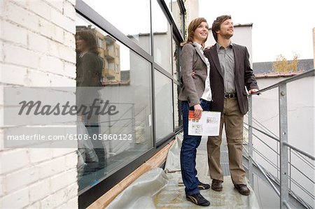 Mid homme adulte et une jeune femme debout sur un balcon