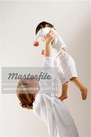 Side profile of a young woman lifting up her son