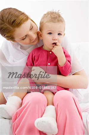 Close-up of a young woman sitting on a couch with her son