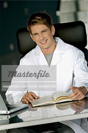 Portrait d'un médecin de sexe masculin assis à un bureau dans son bureau