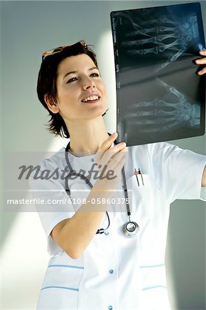 Female doctor examining an X-Ray report and smiling