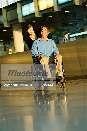 Young woman pushing a male patient sitting in a wheelchair