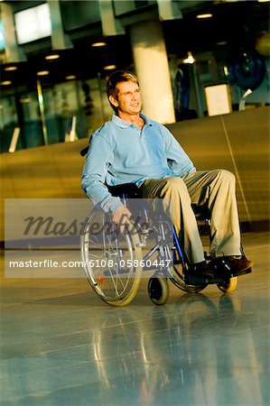Mitte erwachsener Mann sitzt im Rollstuhl