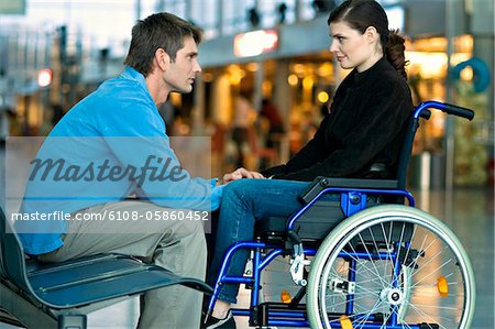 Side profile of a mid adult man talking with a young woman