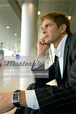 Profil de côté d'un homme d'affaires assis dans un salon d'aéroport