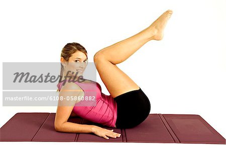 Portrait d'une jeune femme exercice sur un tapis d'exercice