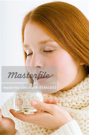 Close-up of a young woman smelling perfume from a bottle