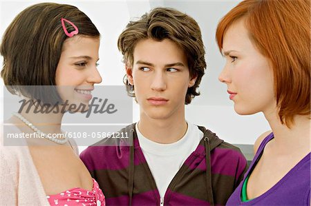 Close-up of a teenage boy with two young women
