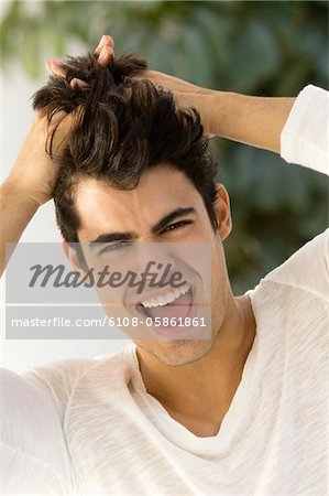 Portrait d'un homme avec ses mains dans ses cheveux