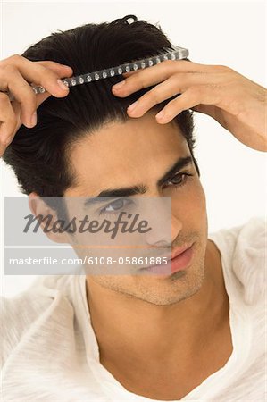Gros plan d'un homme peignant ses cheveux