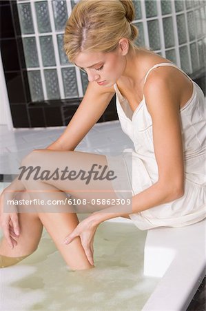 Frau ihre Beine in der Badewanne waschen