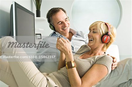 Couple listening to music with headphones and smiling