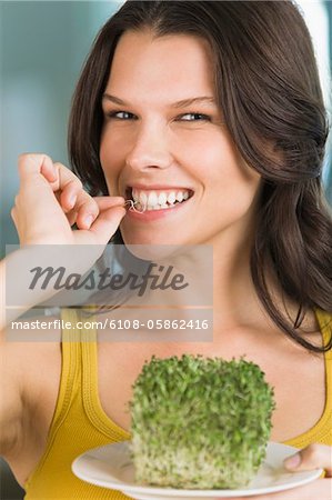 Woman eating bean sprouts and smiling