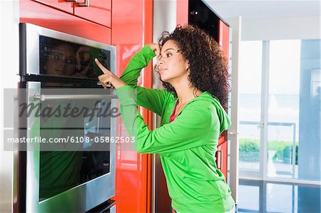 Woman leaning against an oven in the kitchen