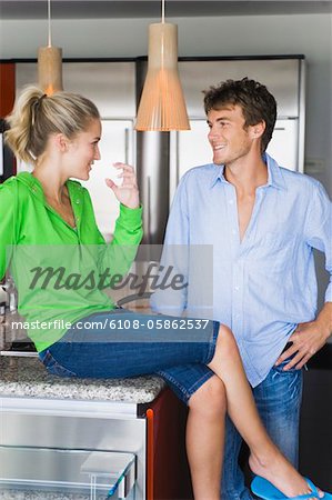 Couple souriant à l'autre dans la cuisine