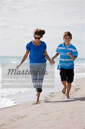 Woman running on the beach with her grandson