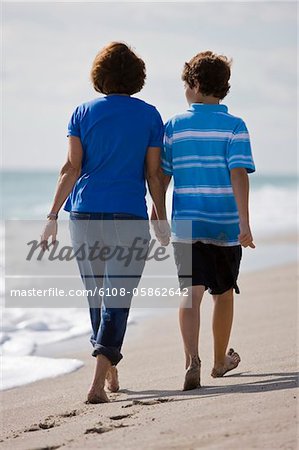 Frau mit ihrem Enkel, Wandern am Strand