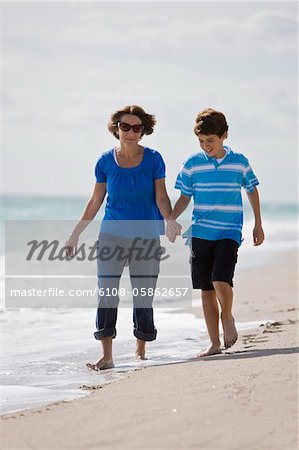 Frau mit ihrem Enkel, Wandern am Strand