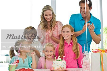 Mädchen mit ihren Eltern und Freunden ihren Geburtstag feiern