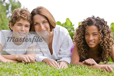 Frau mit ihren Enkeln auf Gras liegend