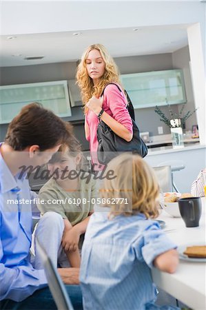 Woman standing beside her family having breakfast