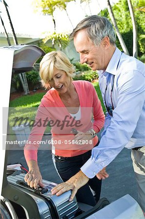 Couple loading luggage into a car