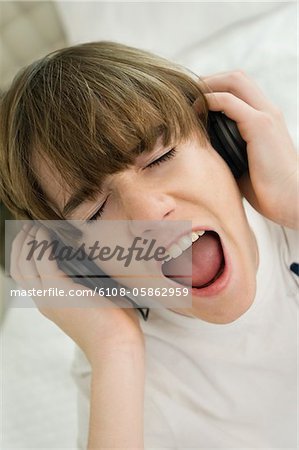 Boy listening to headphones and shouting
