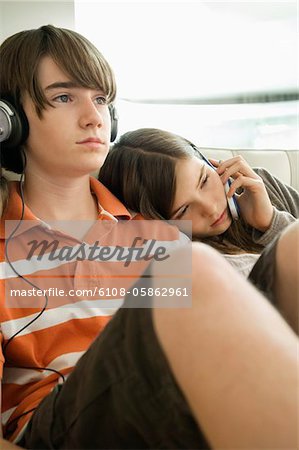 Junge hören Kopfhörer und Mädchen sprechen auf einem Mobiltelefon