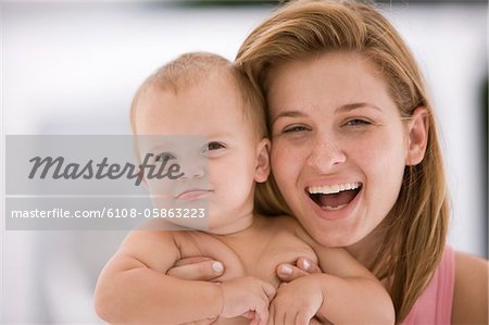Woman holding her daughter and laughing
